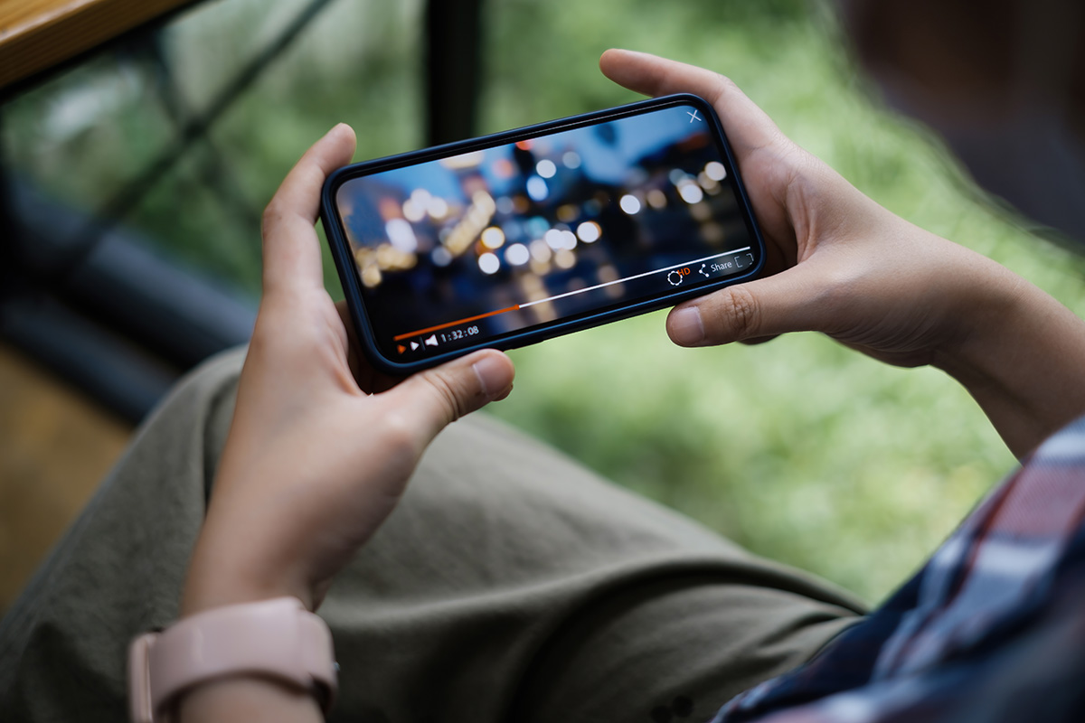 Online video for content marketing concept - man watching a video on his phone.